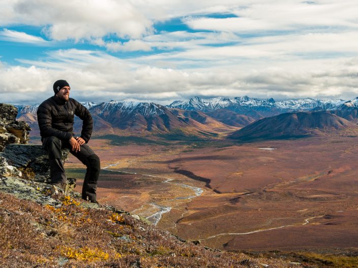 Naturfotograf sitzt auf Berg, Blick in den herbstlichen Denali Nationalpark, Alaska