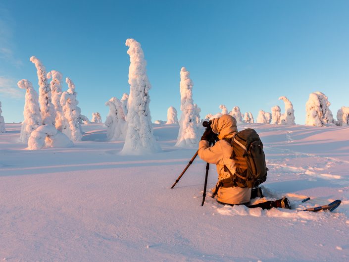 Landschaftsfotograf beim fotografieren der verschneiten Bäume, Riisitunturi Nationalpark, Finnland