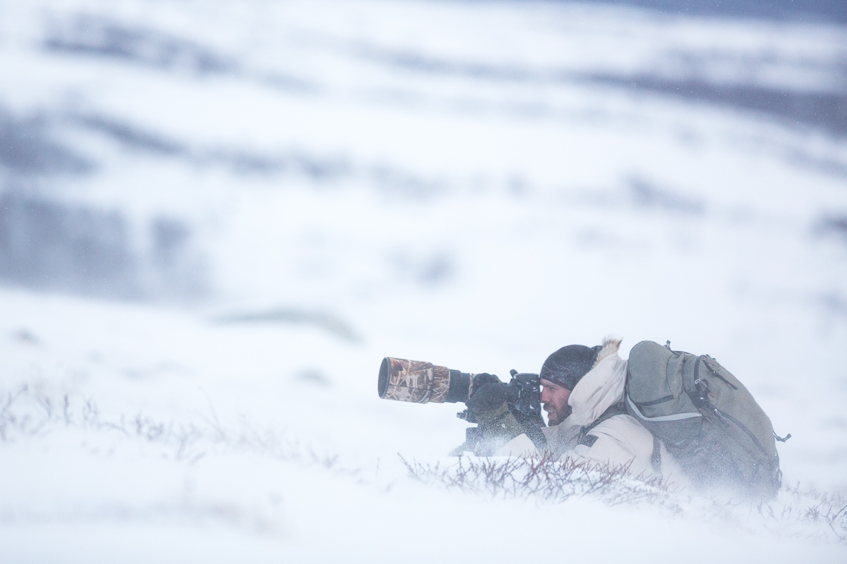 Fotograf mit Fotohandschuhen beim Schneesturm in Norwegen